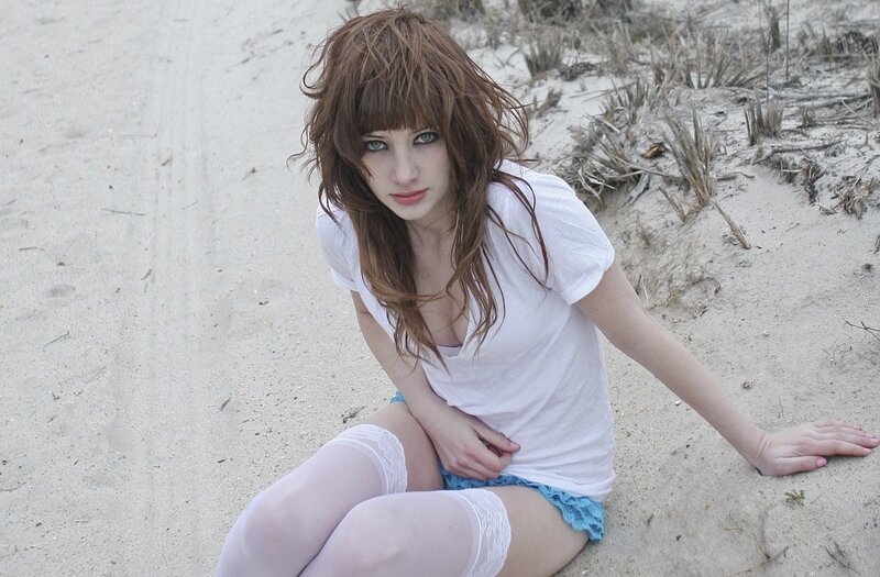 woman sitting on sandy beach