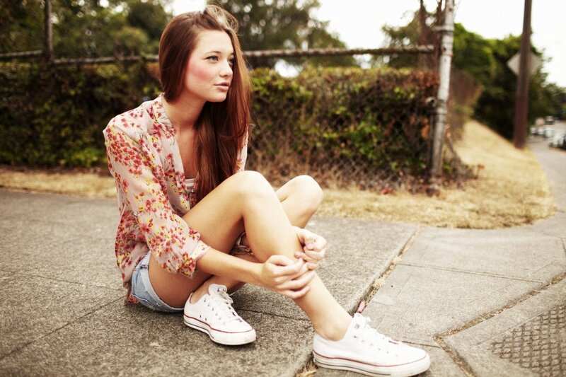 woman sitting on sidewalk