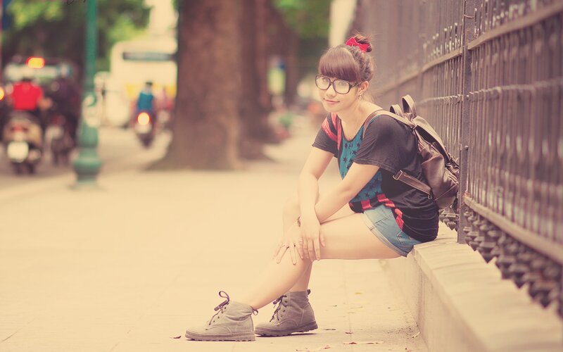 woman sitting on sidewalk
