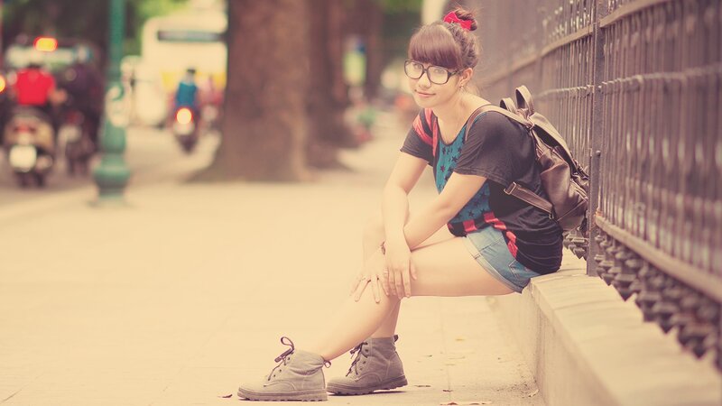 woman sitting on sidewalk