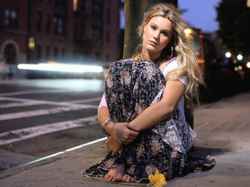 woman sitting on sidewalk at night