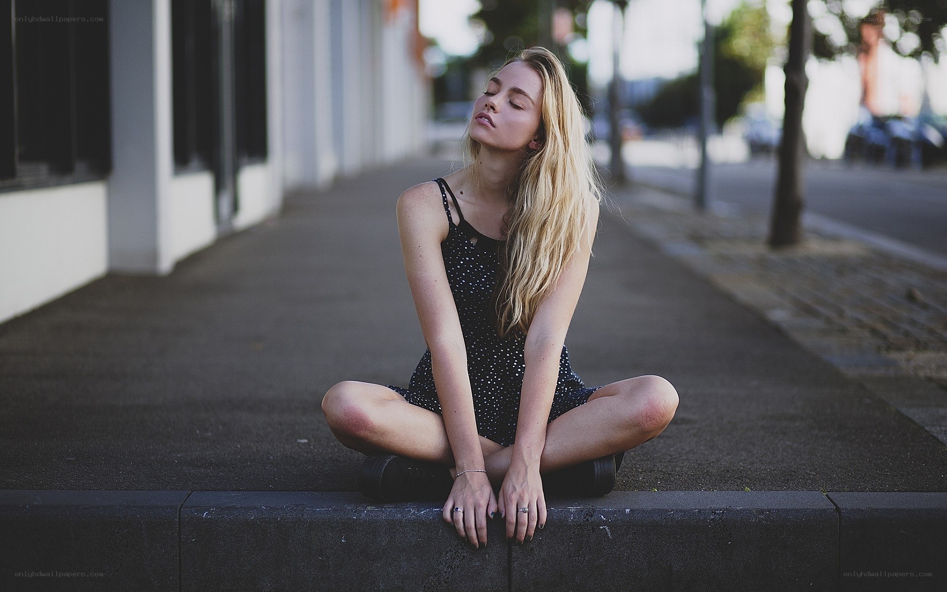 woman sitting on sidewalk