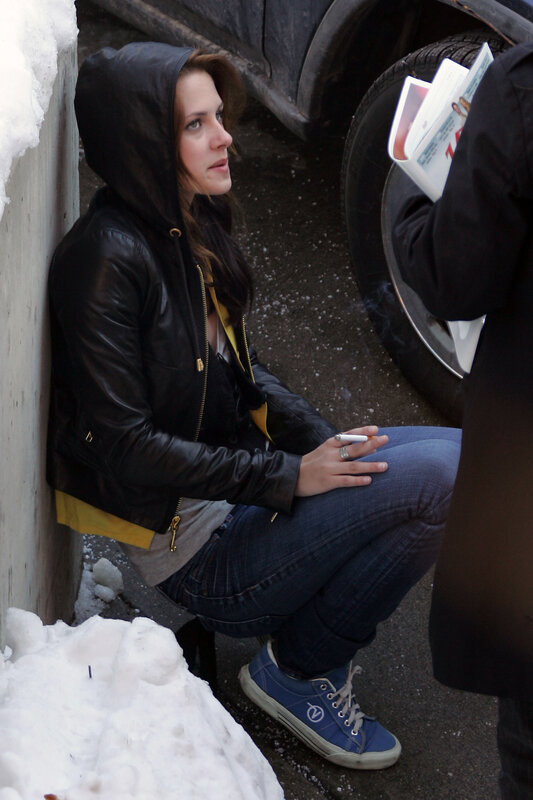 woman sitting on snowy street