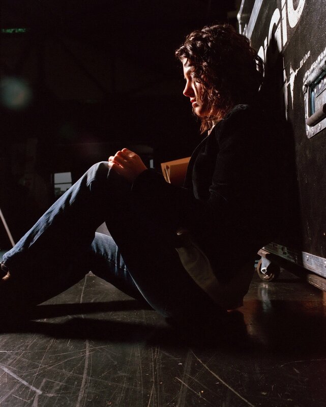 woman sitting on stage floor