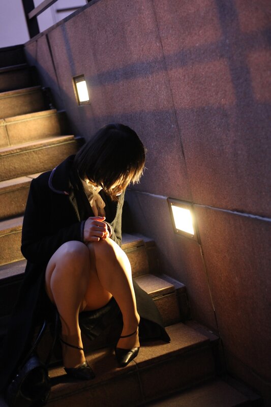 woman sitting on stairs at night