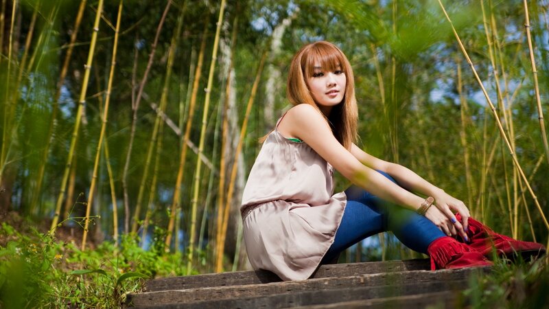 woman sitting on steps in bamboo forest