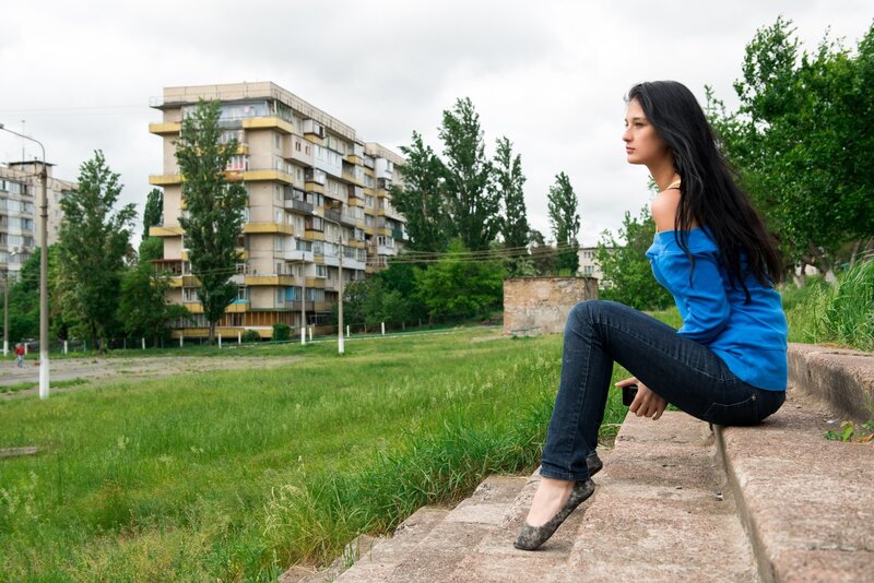Woman sitting on steps in urban park
