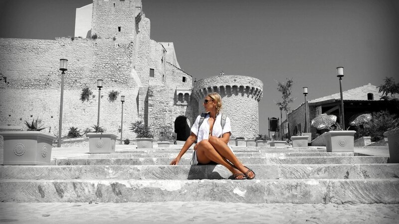 Woman sitting on steps near castle
