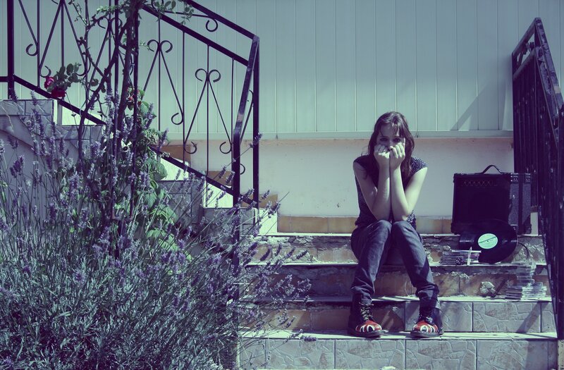 woman sitting on steps with record player