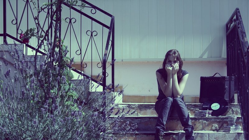 woman sitting on steps with record player