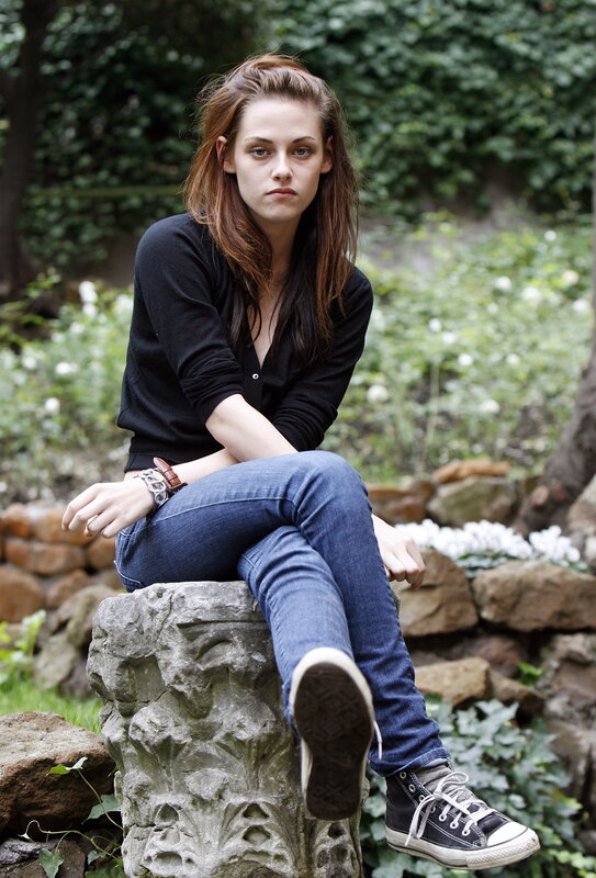 woman sitting on stone in garden