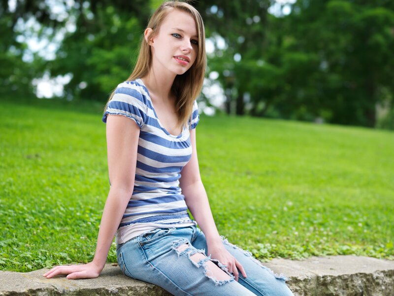 woman sitting on stone in park