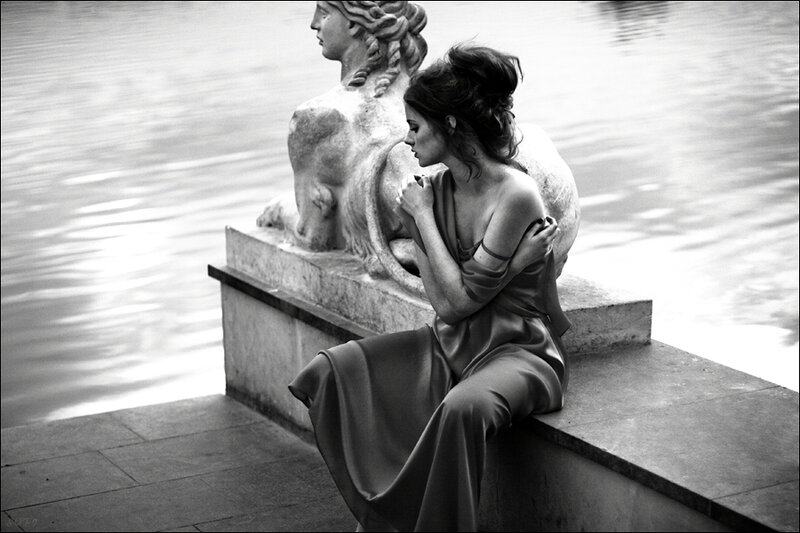 Woman Sitting on Stone Ledge — Black, Dramatic
