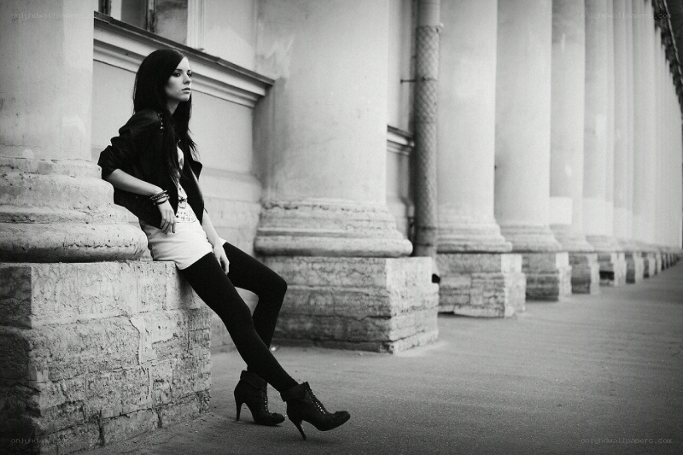 woman sitting on stone pillar