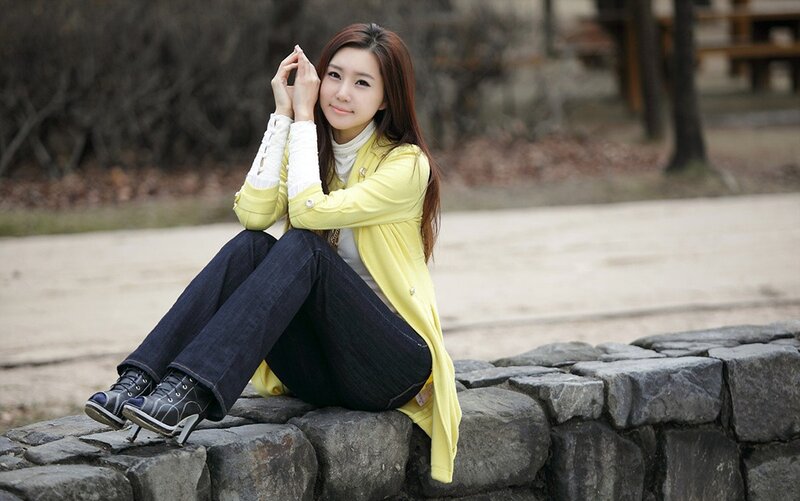 woman sitting on stone wall