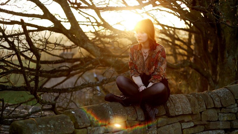woman sitting on stone wall
