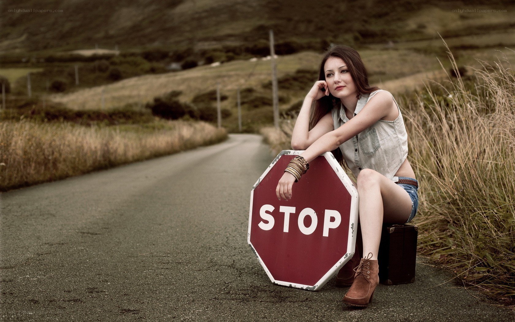 woman sitting on stop sign