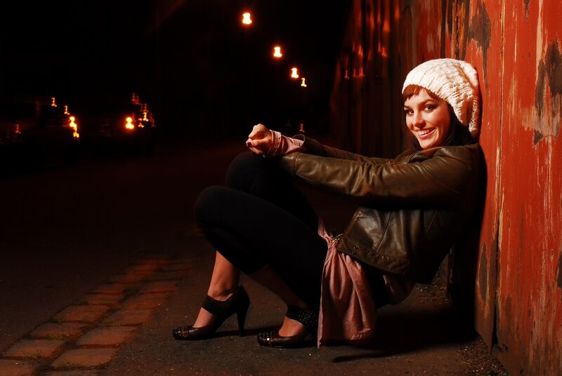 Woman sitting on street at night