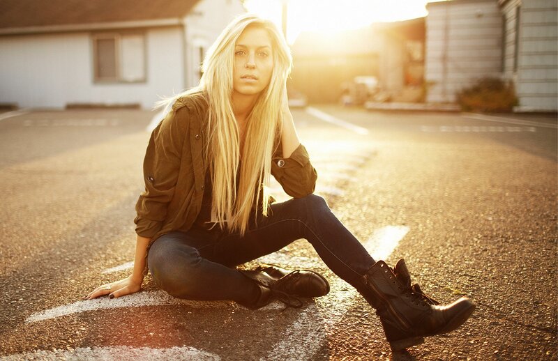 woman sitting on street at sunset