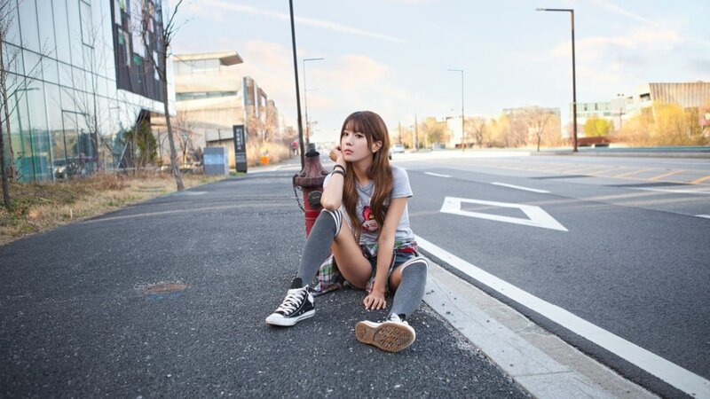 Woman sitting on street curb