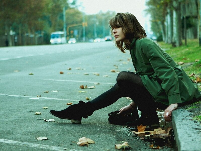 Woman sitting on street curb