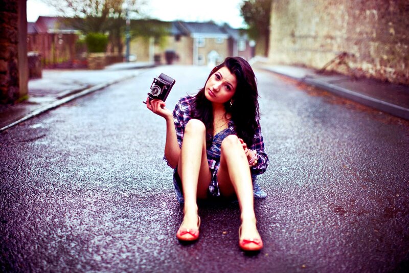 woman sitting on street with camera