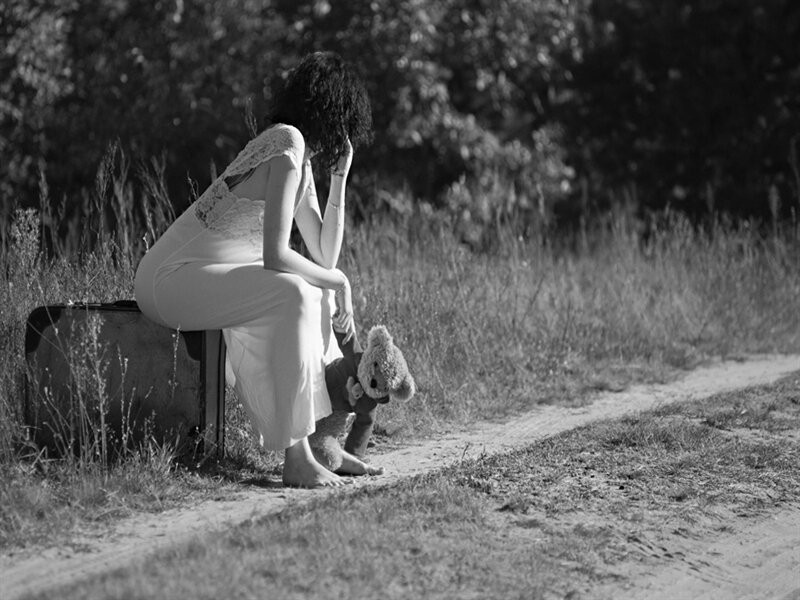 Woman Sitting on Suitcase — Black