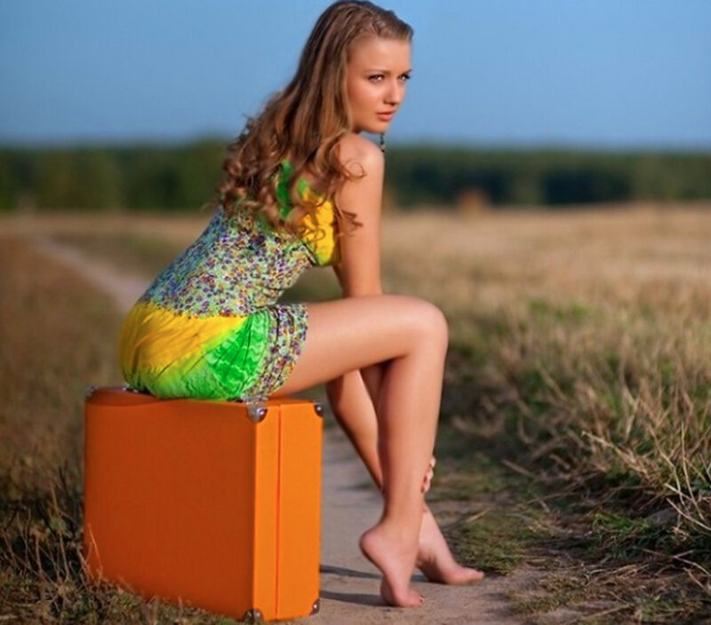 Woman Sitting on Suitcase — Orange