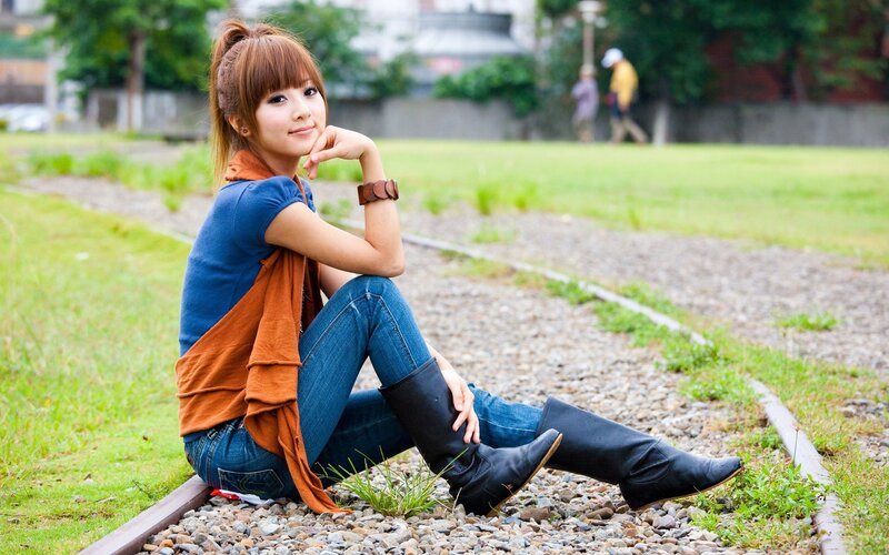 woman sitting on train tracks
