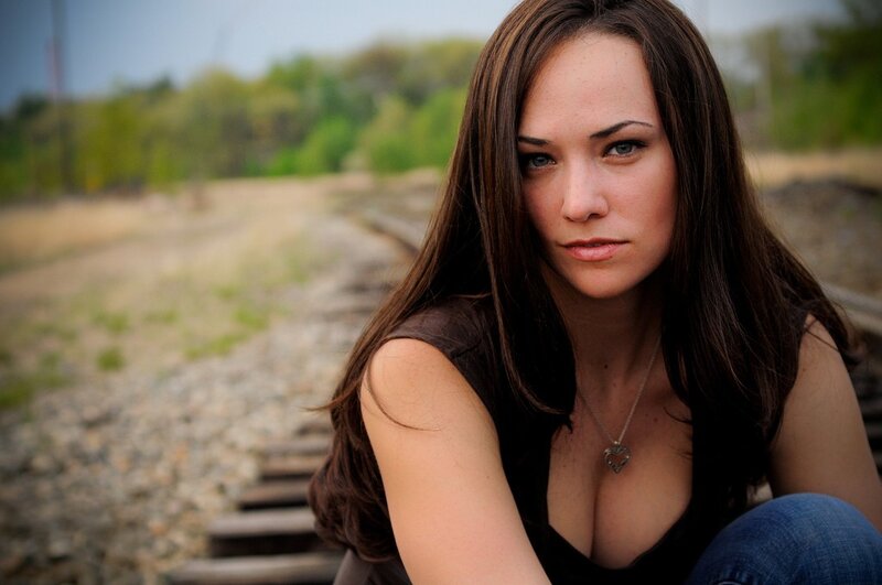 woman sitting on train tracks