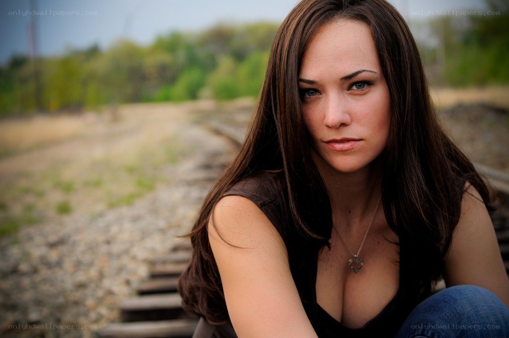 woman sitting on train tracks