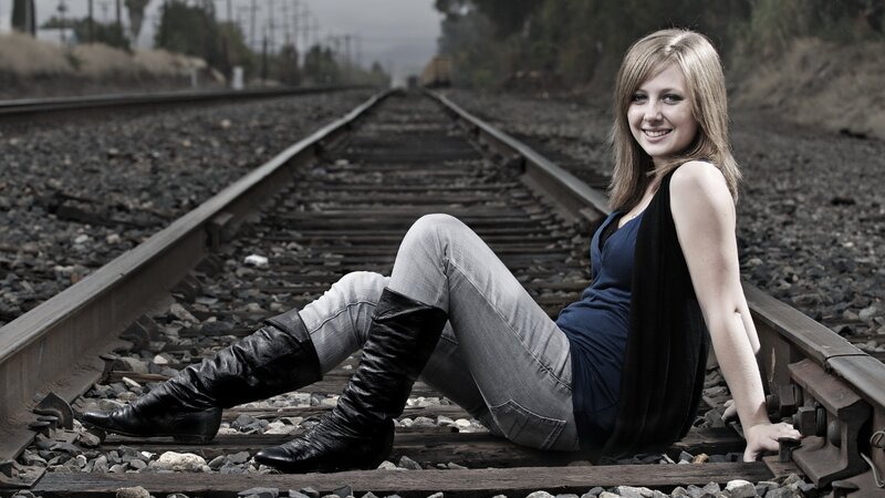 Woman sitting on train tracks