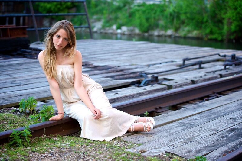 woman sitting on train tracks