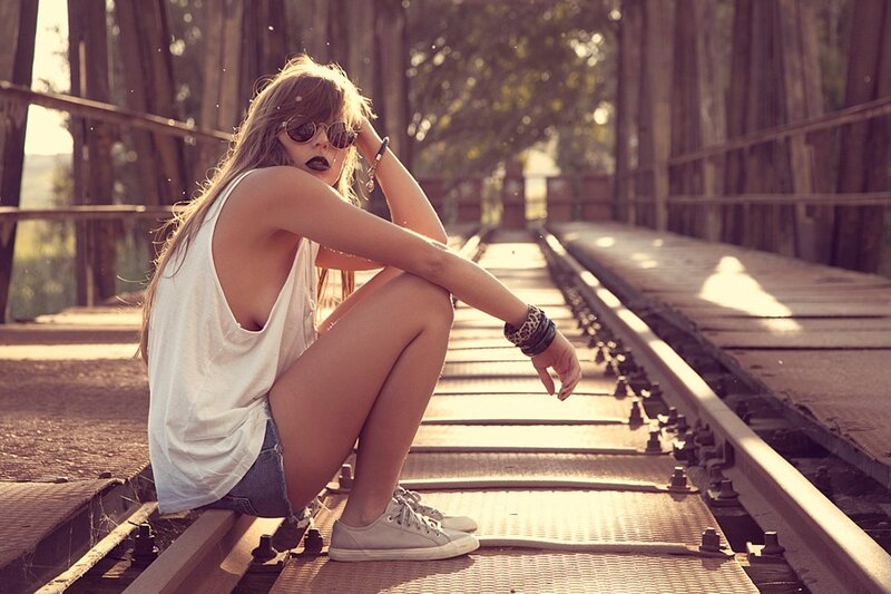 woman sitting on train tracks