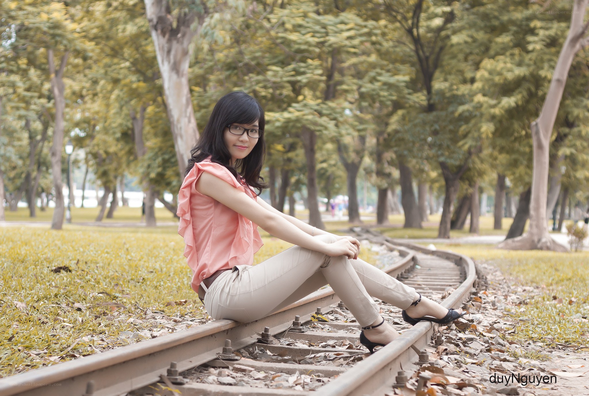 Woman sitting on train tracks