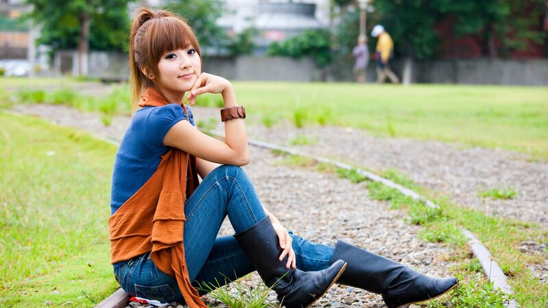 woman sitting on train tracks