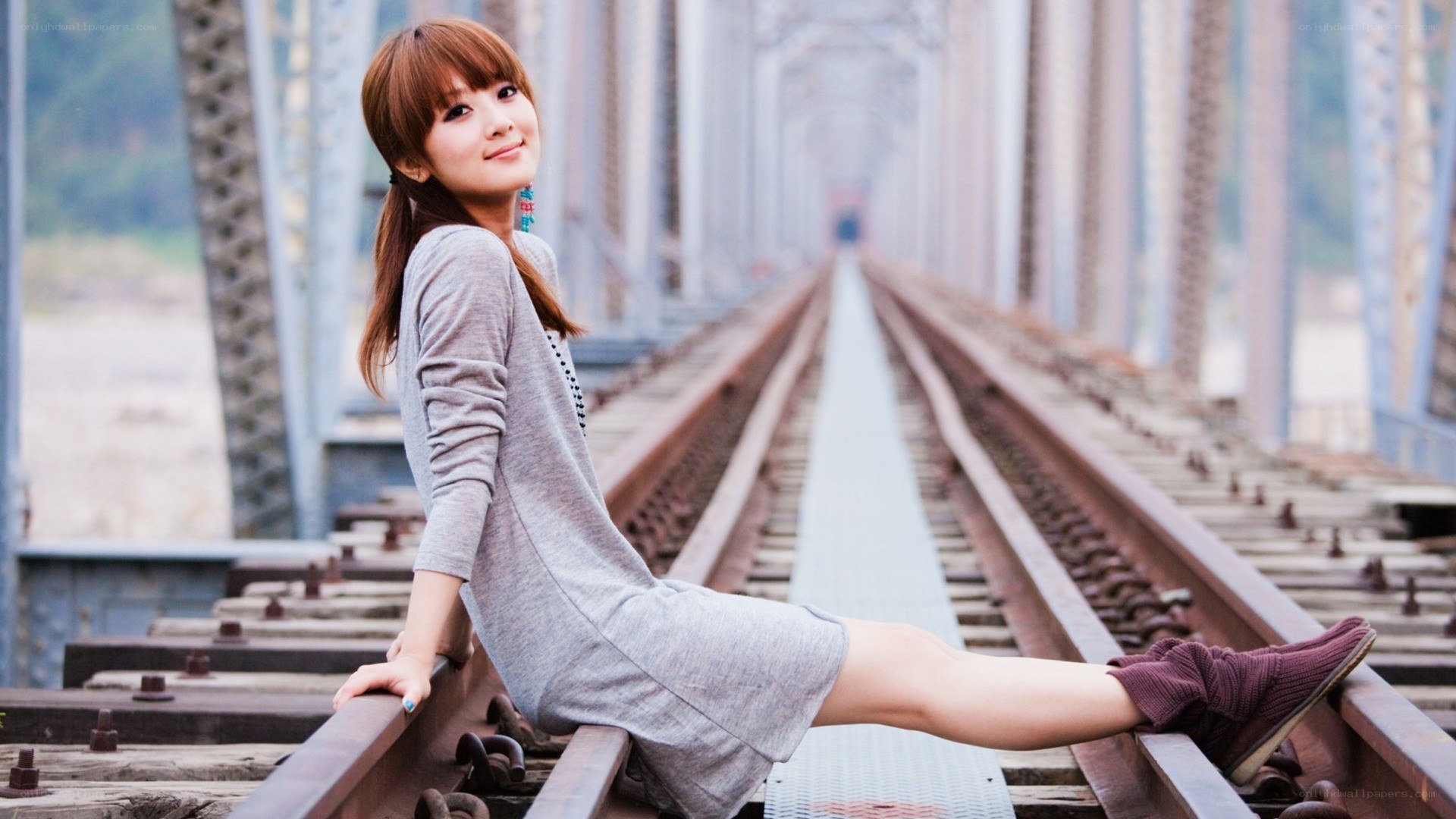 Woman sitting on train tracks