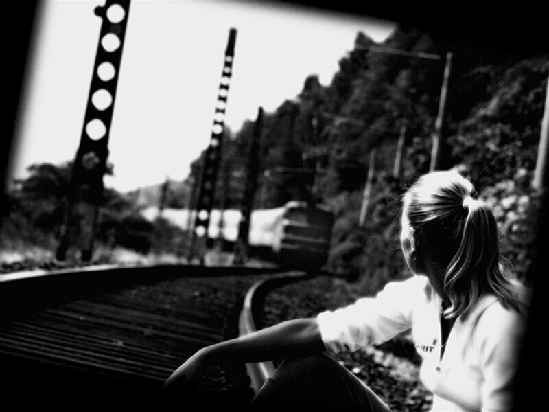 Woman Sitting on Train Tracks — Black, Contemplative