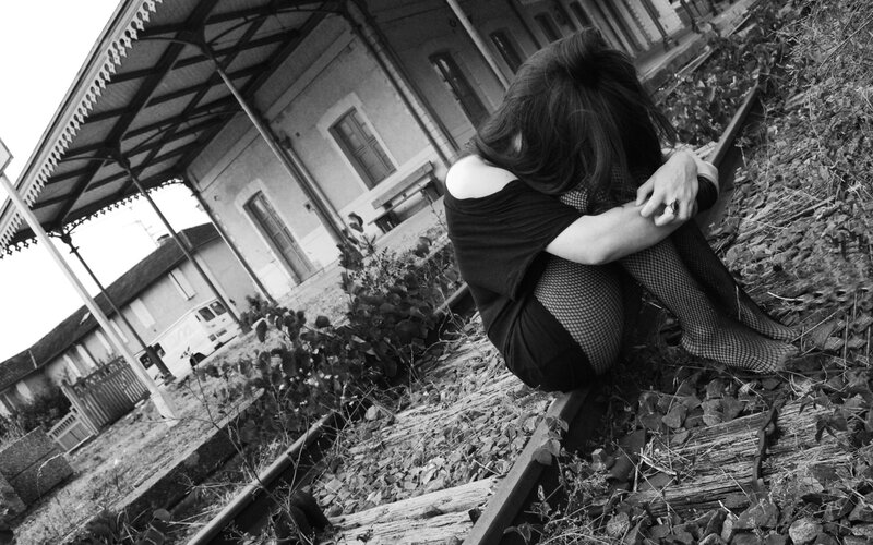 Woman Sitting on Train Tracks — Black, Melancholic