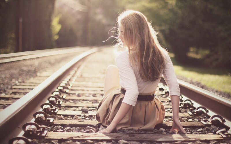 Woman Sitting on Train Tracks — Brown, Serene