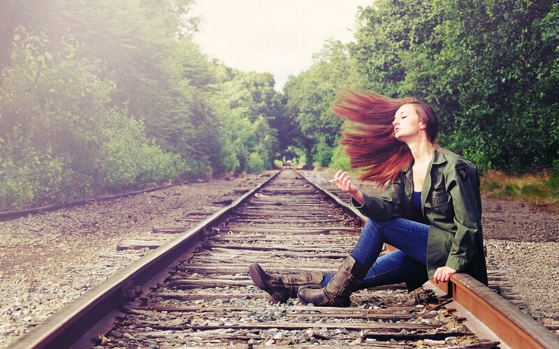 Woman Sitting on Train Tracks — Green, Contemplative, Afternoon