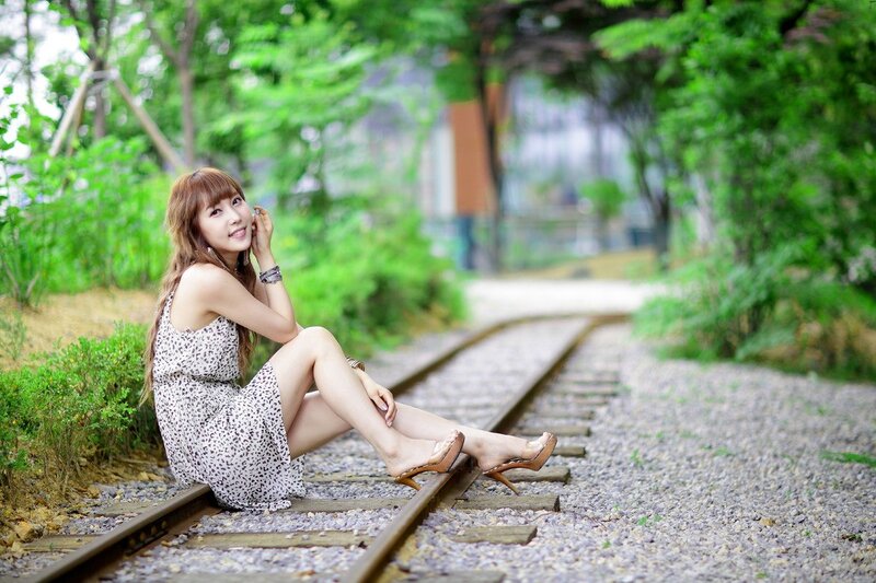 Woman Sitting on Train Tracks — Green, Serene