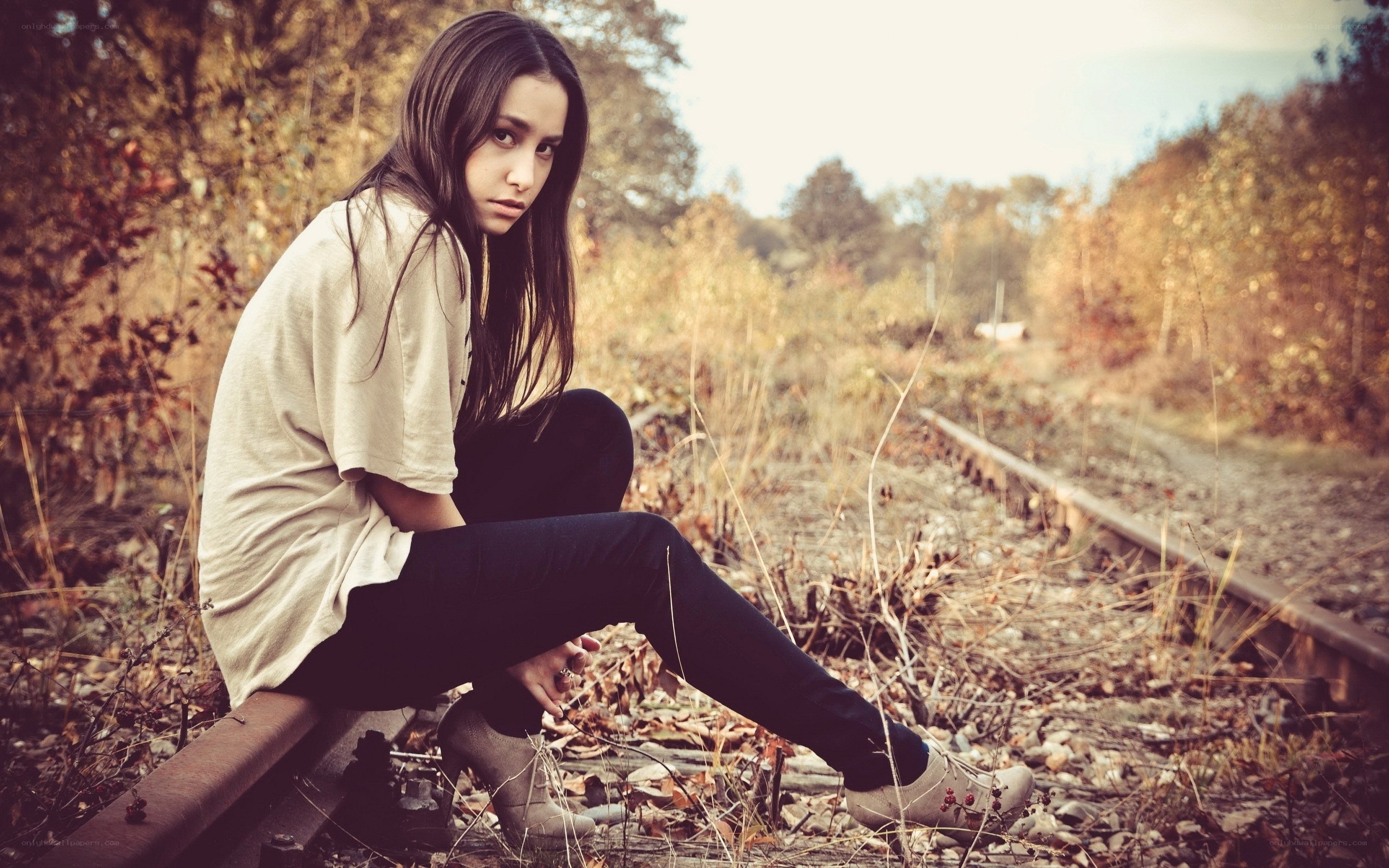 woman sitting on train tracks