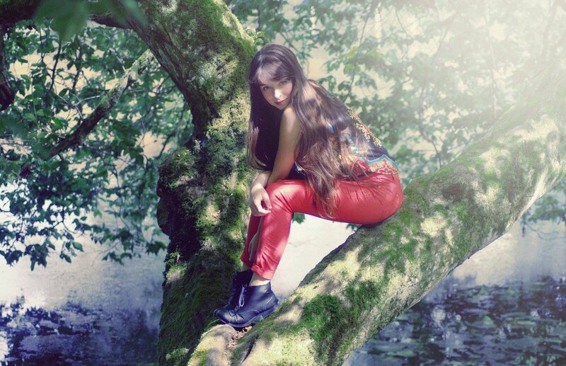 woman sitting on tree branch