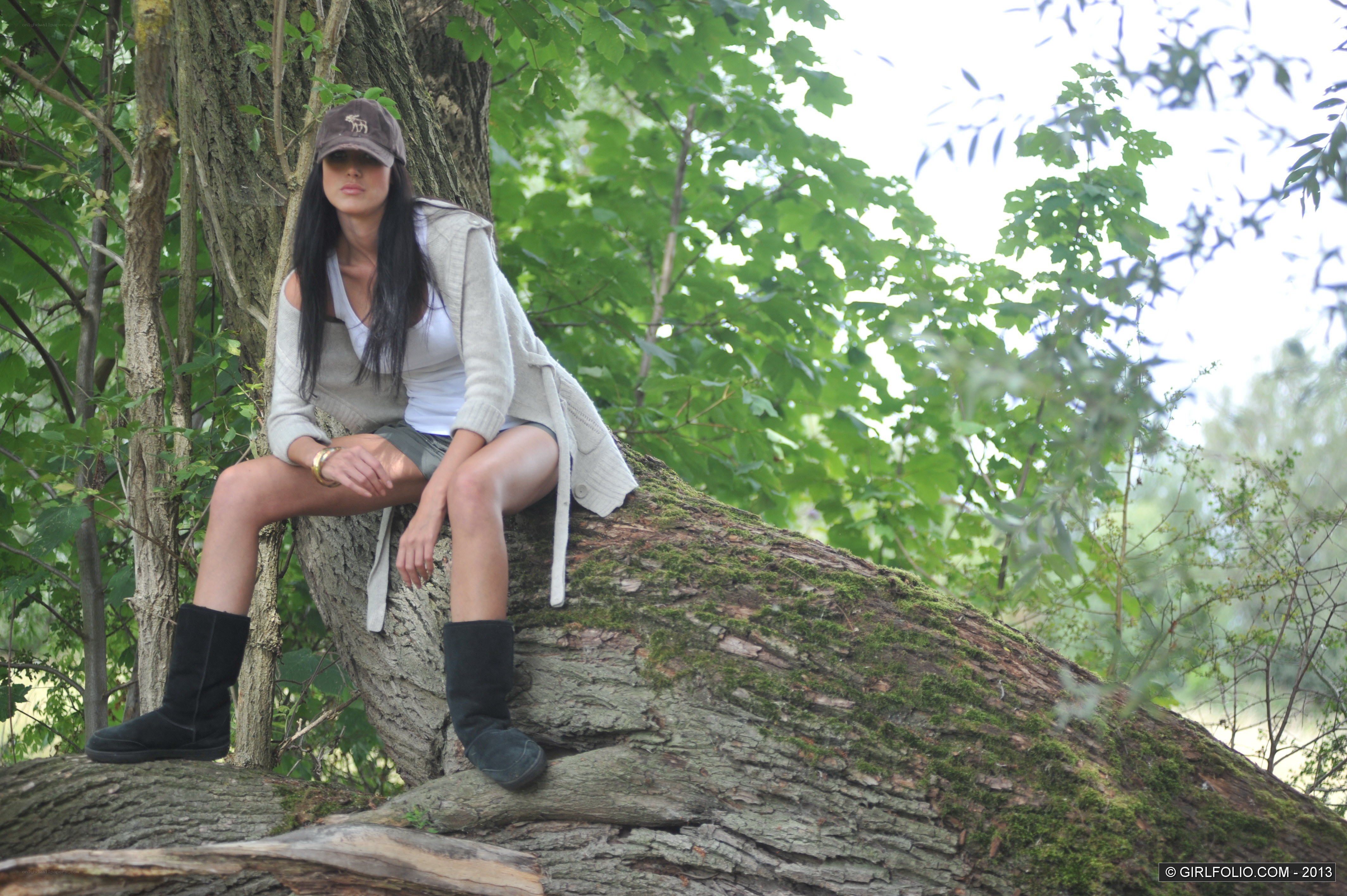 woman sitting on tree trunk