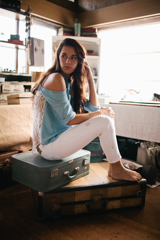 woman sitting on vintage suitcases