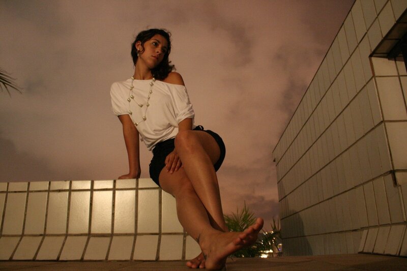 woman sitting on wall at dusk