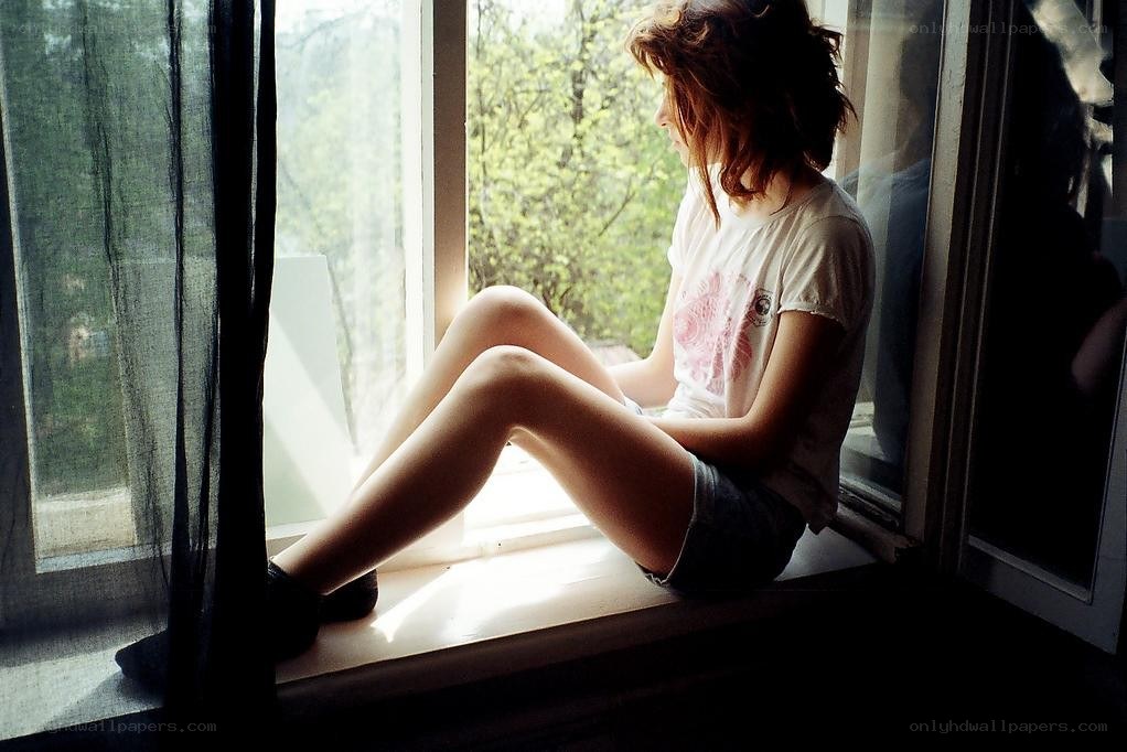 woman sitting on windowsill