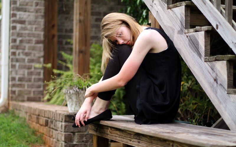 woman sitting on wooden bench