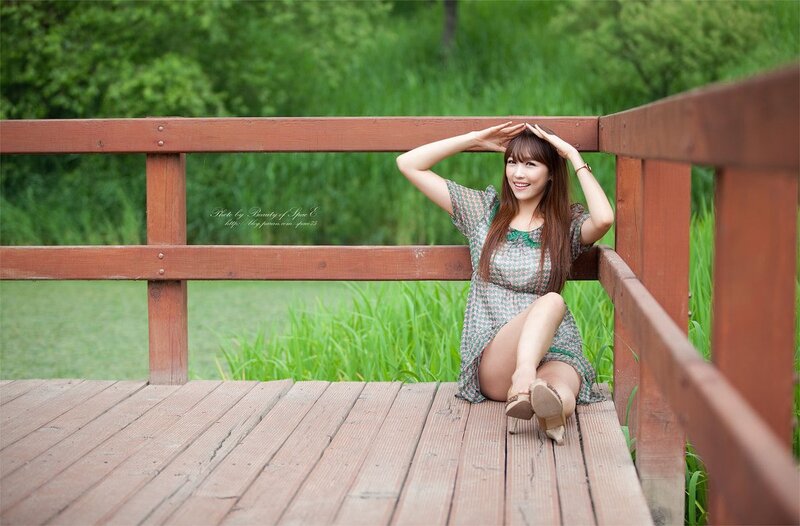 woman sitting on wooden bridge